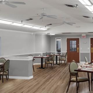 An empty dining area with modern furnishings and soft lighting.