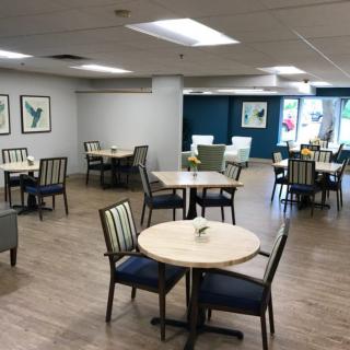 A spacious and well-lit dining area with neatly arranged tables and chairs.