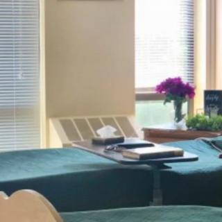 A cozy room with sofas, a small table, books, and a vase of flowers near a window.