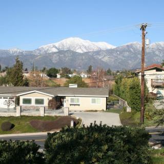 A view of a snow-capped mountain behind a residential neighborhood on a clear day.