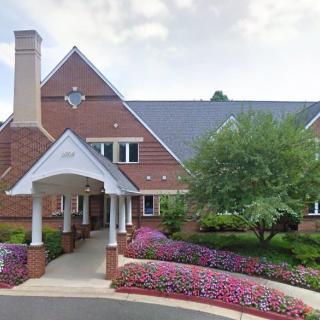 Beautiful brick house with landscaped gardens and a covered entrance.