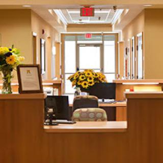 A welcoming reception area featuring a desk, flowers, and a bright entrance.