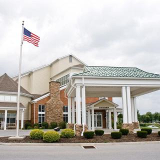 A hotel entrance with an American flag flying outside.