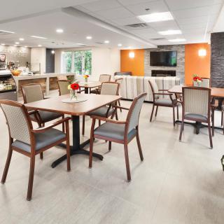 A modern dining area with neatly arranged tables and chairs, featuring a warm and inviting atmosphere.