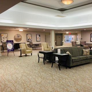 A spacious lobby area featuring sofas and chairs, with elegant decor and lighting.