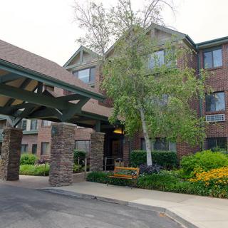 A well-maintained brick building with a covered entrance and lush landscaping.