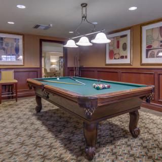 A cozy game room featuring a classic billiard table under stylish lighting.