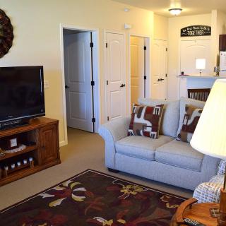 A cozy living room with a sofa, television, and home decor.