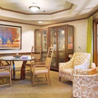 A cozy living room with a seating area, featuring elegant furniture and decorative artwork.