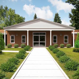 A welcoming facade of a modern building surrounded by greenery.