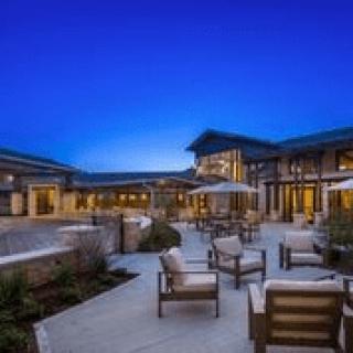 A modern outdoor patio area with chairs at dusk.
