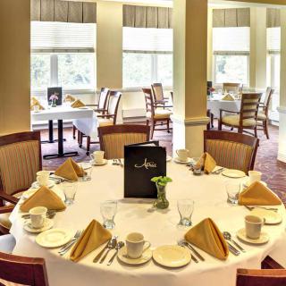 An elegantly set dining table in a restaurant with neatly arranged napkins and crockery.