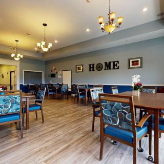 A cozy dining room with elegant chandeliers and wooden flooring.