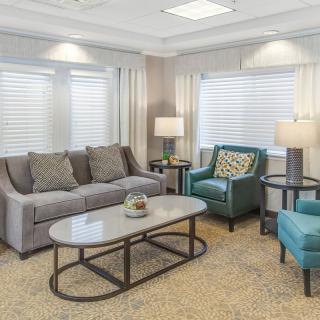 A cozy living room with a sofa, armchairs, coffee table, and lamps.