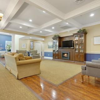 A spacious living room featuring comfortable seating, a fireplace, and a television.