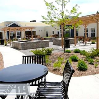 A well-maintained outdoor patio area with seating and landscaping in a courtyard setting.