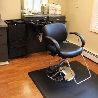 An interior view of a hair salon, featuring a barber chair and salon equipment.