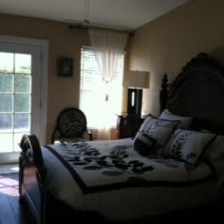 A cozy bedroom with a neatly made bed and natural light coming through the window.