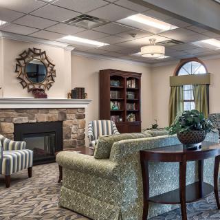 A cozy living room with a fireplace, comfortable seating, and elegant decor.