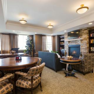 A cozy living room with a fireplace, bookshelves, and comfortable seating.