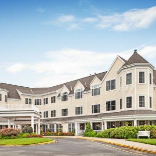 A residential building with landscaped surroundings under a clear blue sky.