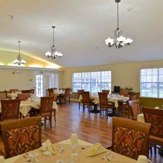 A spacious and elegantly decorated dining room with several tables and chairs set up for guests.