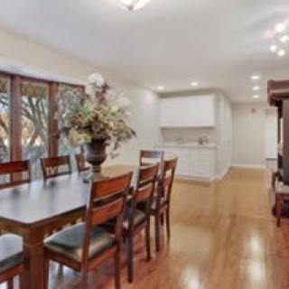 A spacious dining area with a large table and chairs, adjacent to a modern kitchen setting.