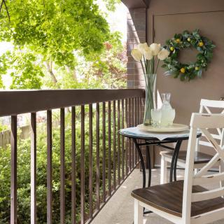 A cozy balcony with a small table, chairs, and decorative elements.
