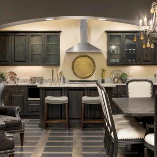 A modern kitchen with dark cabinets and a cozy dining area.