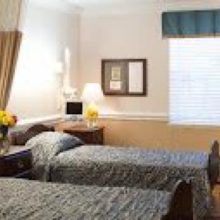 A cozy bedroom with twin beds and a warm lamp.