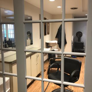 A cozy barbershop interior with a chair, mirrors, and barber tools.