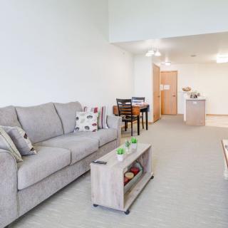 A modern living room with a cozy sofa and coffee table, adjacent to a dining area.