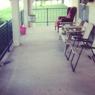 A serene porch with several chairs and a small table, perfect for relaxation.