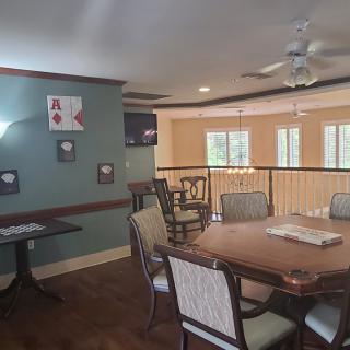 A cozy dining area with a wooden table, chairs, and decorative elements on the wall.