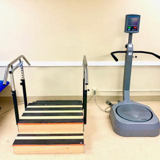 A rehabilitation area featuring a set of stairs and a vibration plate.