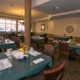 A cozy dining room with tables set for a meal.