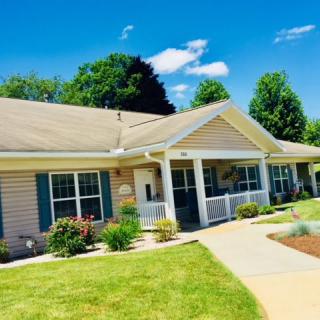 A charming house with a well-maintained garden on a sunny day.
