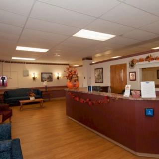 A hospital reception area with a desk, seating, and decorations.