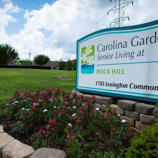 Entrance sign for Carolina Gardens Senior Living at Rock Hill surrounded by a landscaped garden.