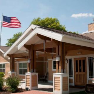 A residential building entrance with an American flag flying above.