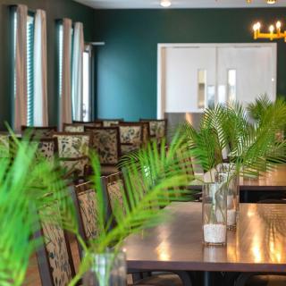 A modern dining room with elegant decor and greenery.