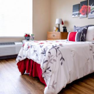 A cozy bedroom with a neatly made bed and tasteful decor.