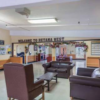 Cozy waiting area with comfortable seating and a welcoming sign.