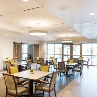 A well-lit modern dining area featuring stylish furniture and ample natural light.
