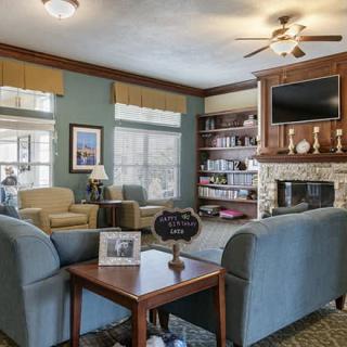A cozy living room with a fireplace, bookshelves, and comfortable seating.