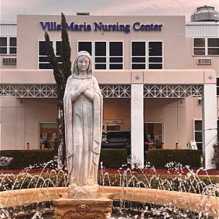 View of the Villa Maria Nursing Center featuring a serene fountain and statue.