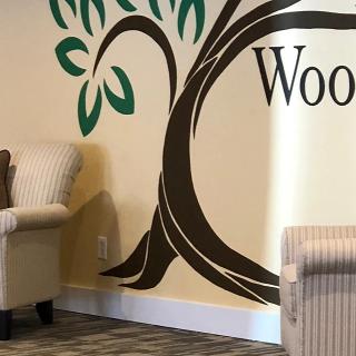 A cozy waiting area featuring a tree mural on the wall and striped upholstered chairs.