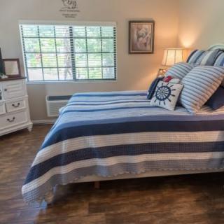 A cozy bedroom with striped bedding and a well-lit window.