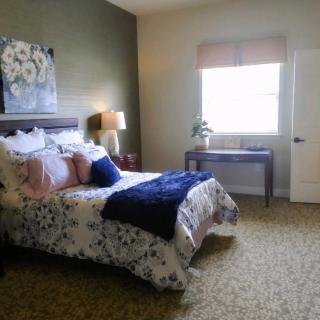A cozy bedroom featuring a neatly made bed, soft lighting, and tasteful decor.