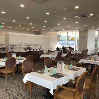 An empty restaurant dining area with neatly arranged tables and chairs.